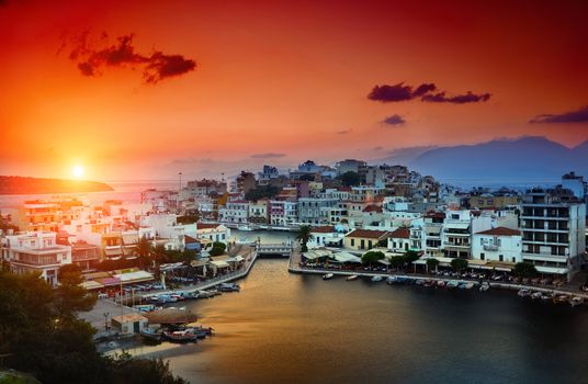 Agios Nikolaos. Agios Nikolaos is a picturesque town in the eastern part of the island Crete built on the northwest side of the peaceful bay of Mirabello.