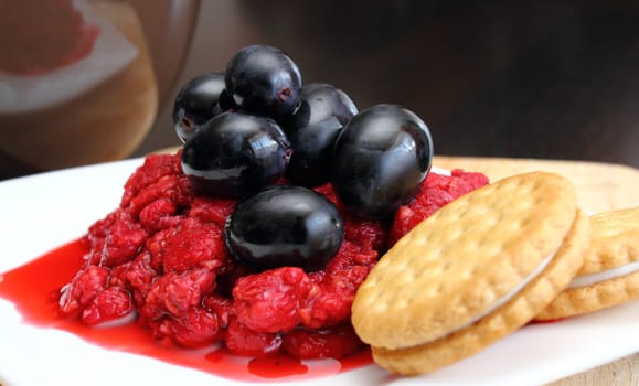 dessert of raspberry and grapes on a white plate