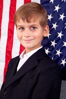 Portait of Caucasian boy with American flag in background.