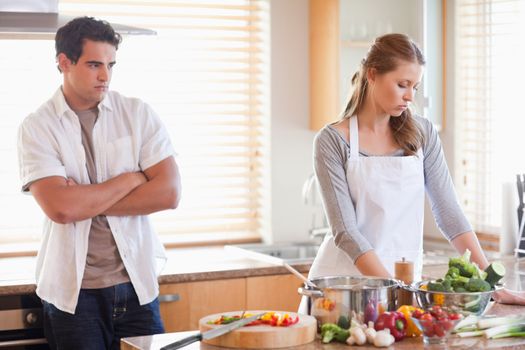 Young man watches his girlfriend cooking