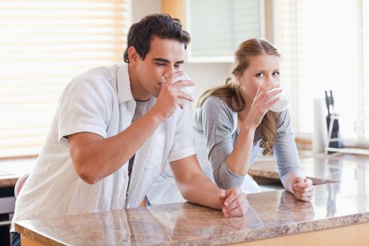 Young couple enjoying some milk in the kitchen