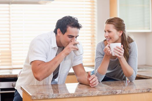Young couple drinking coffee in the kitchen