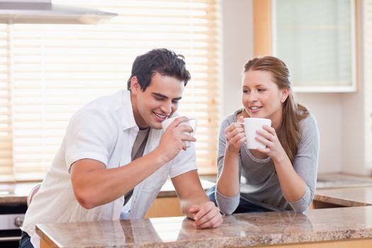 Young couple having tea in the kitchen