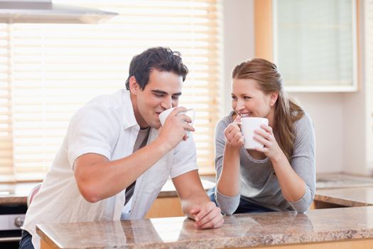 Young couple drinking in the kitchen