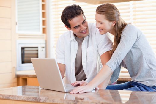 Young couple with laptop in the kitchen