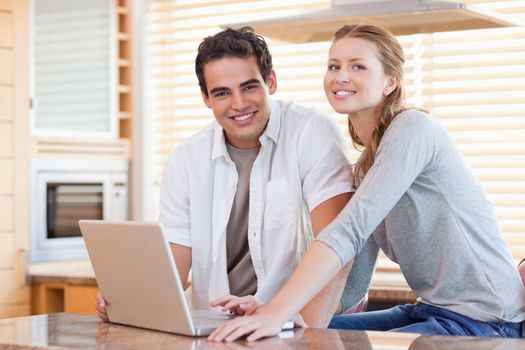 Young couple with notebook in the kitchen