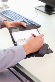 Young businessman taking notes on his pocket calender