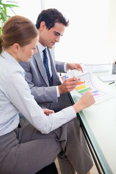 Side view of young colleagues analyzing statistics together