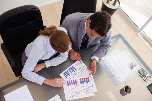 Above view of young consultant analyzing data with her client