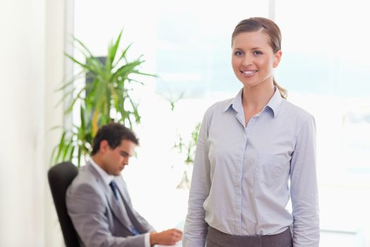 Young tradeswoman with colleague behind her