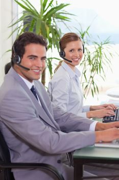 Side view of smiling young call center agents