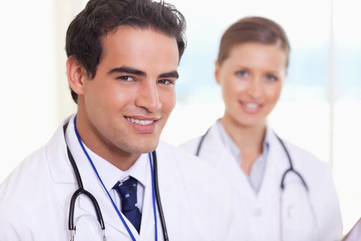 Smiling young medical assistants standing next to each other