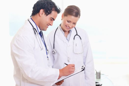 Smiling young medical staff working on patient record