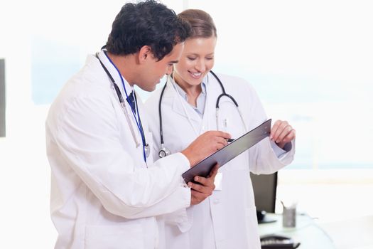 Young assistant doctors reading off clip board