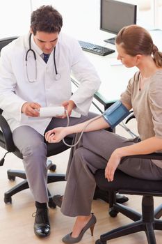 Side view of young doctor taking his patients blood pressure