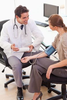 Young doctor is relieved after taking his patients blood pressure