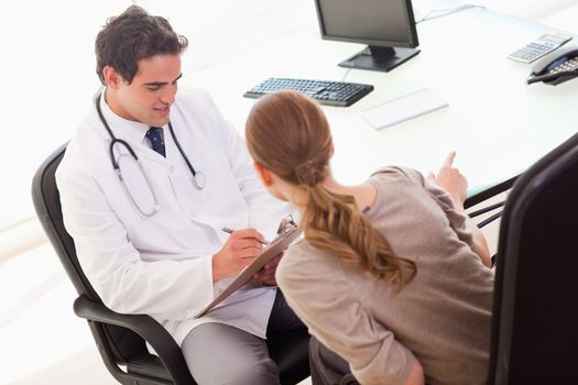 Young patient describing symptoms to her doctor