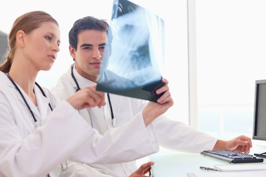 Young doctor showing her colleague an x-ray