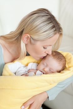 Affectionate young mother kissing her baby's forehead