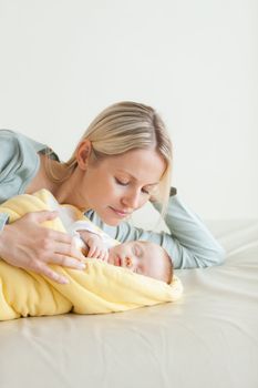 Young mother lying next to her sleeping baby