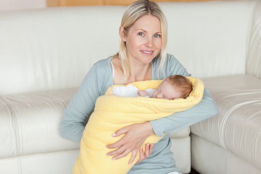 Young mother sitting on the floor with her baby in her arms