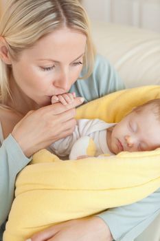 Close up of young mother kissing her baby's hand