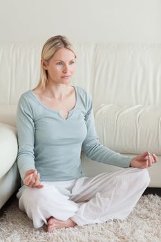 Young woman sitting on the floor doing yoga