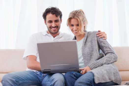 Couple using a laptop in their living room