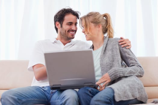 Young couple using a laptop in their living room