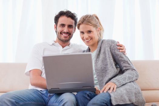 Young couple using a notebook in their living room