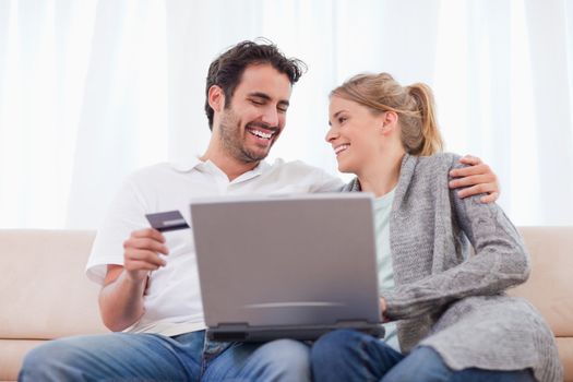 Young couple shopping online in their living room