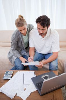 Portrait of a couple doing their accounting with a notebook in their living room