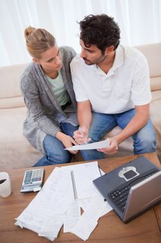 Portrait of a young couple doing their accounting with a notebook in their living room