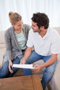 Portrait of a young couple reading a letter in their living room