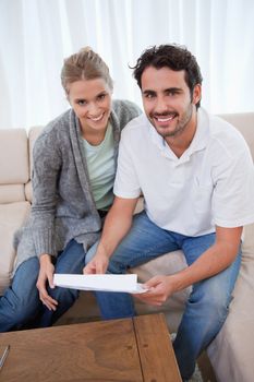 Portrait of a happy couple reading a letter in their living room