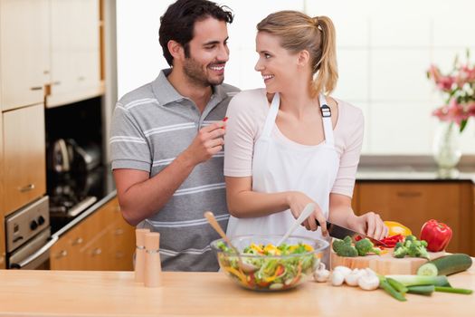 Young couple slicing vegetables in their living room