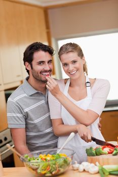 Portrait of a charming couple cooking in their kitchen