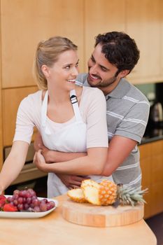 Portrait of a couple eating fruits in their kitchen