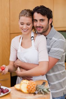 Portrait of an in love couple eating fruits in their kitchen