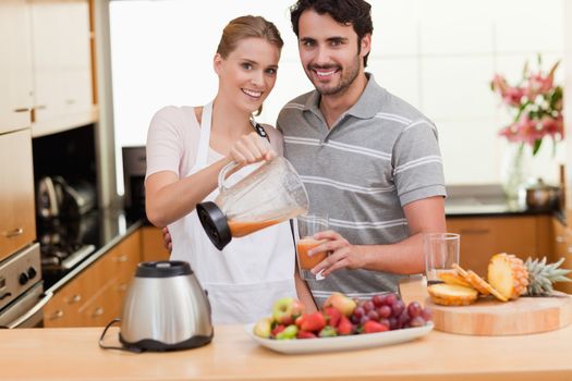 Couple drinking fruits juice in their kitchen