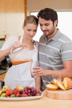 Portrait of a couple drinking fruits juice in their kitchen