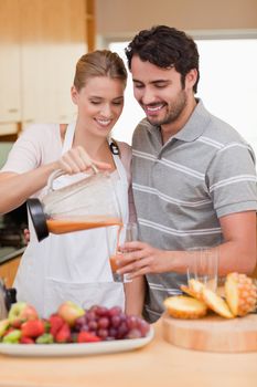 Portrait of a young couple drinking fruits juice in their kitchen