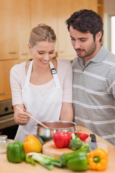 Portrait of a couple preparing a sauce in their kitchen