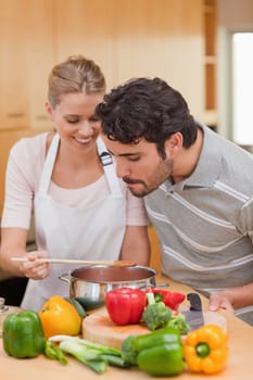 Portrait of a happy couple preparing a sauce in their kitchen