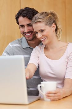 Portrait of a couple using a notebook while having tea in their kitchen