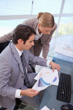 Portrait of a manager and his secretary looking at a graph in his office