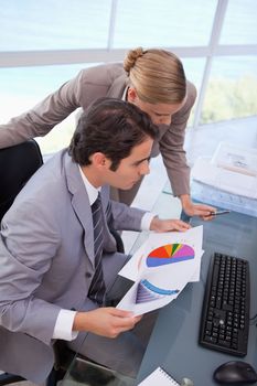 Portrait of a business team looking at a graph in an office