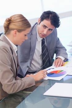 Portrait of young business people studying statistics in a meeting room