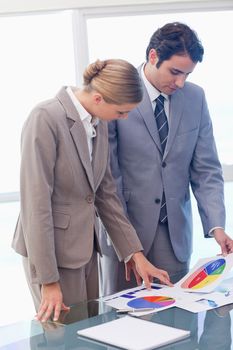 Portrait of young business people looking at statistics in a meeting room