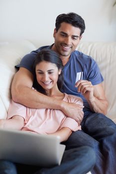 Portrait of a couple booking their holidays online in their living room